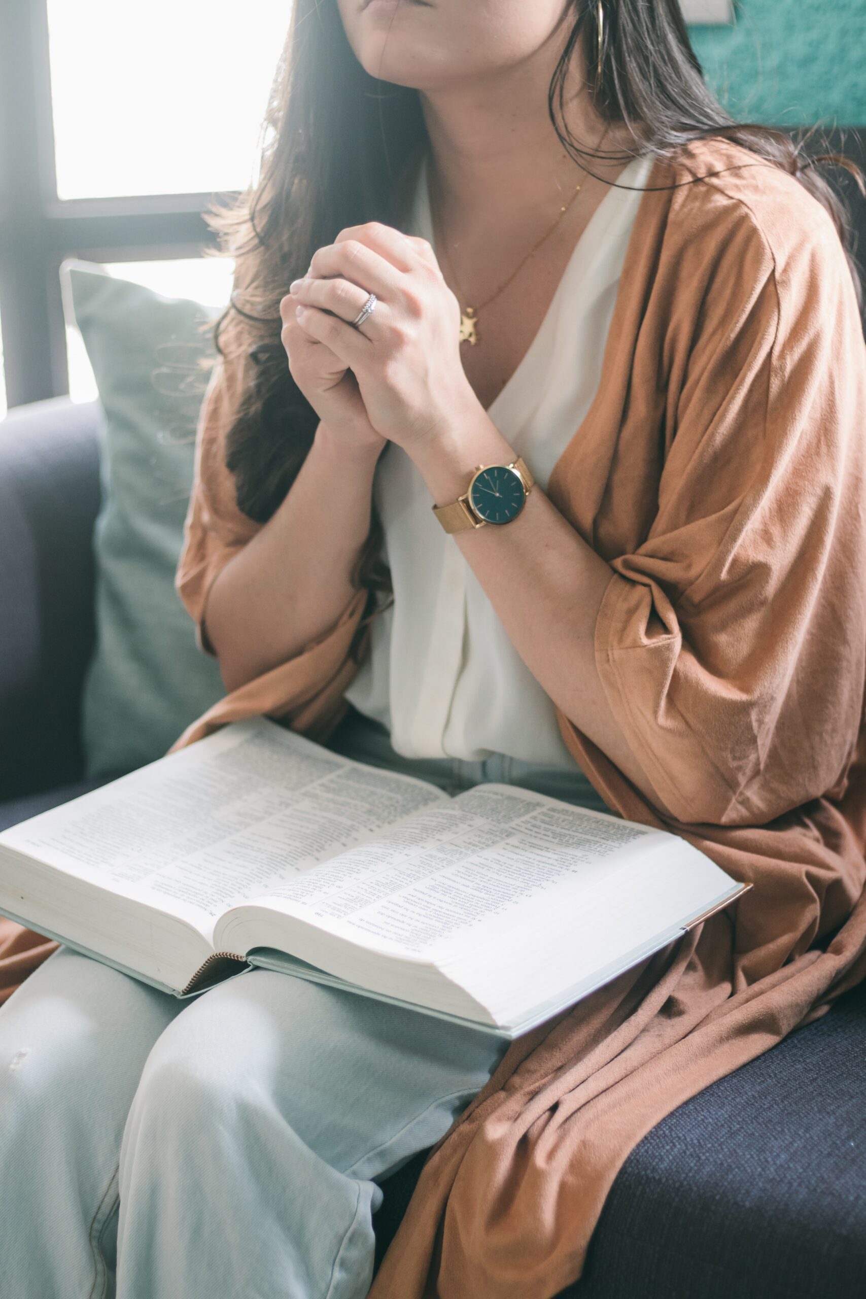 praying without an answer can be frustrating woman praying with Bible in lap