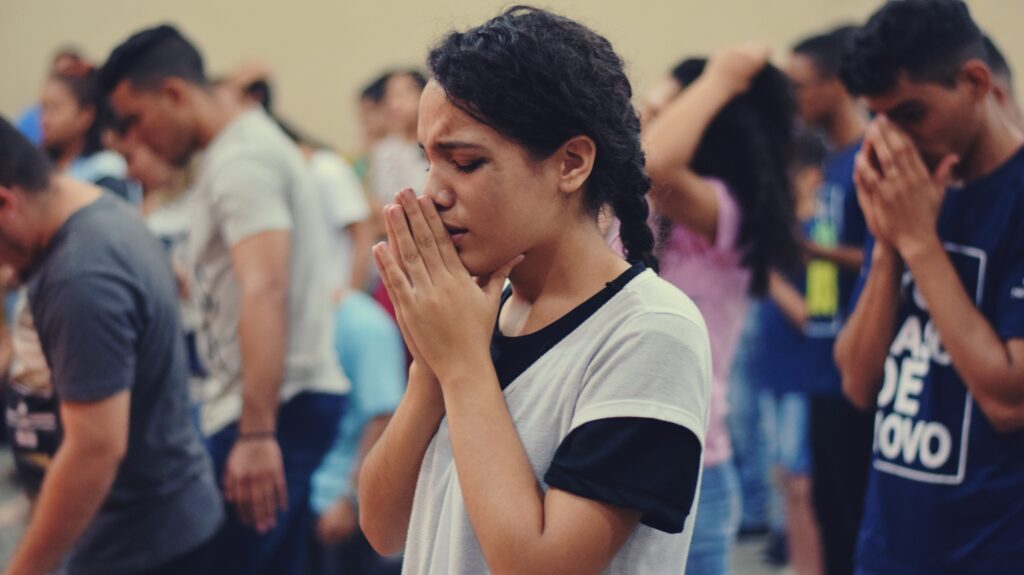 Does prayer work? Woman earnestly praying in church